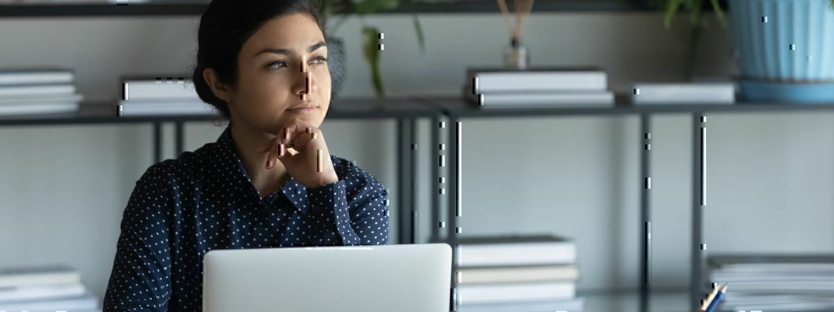 Frau am Laptop denkt nach